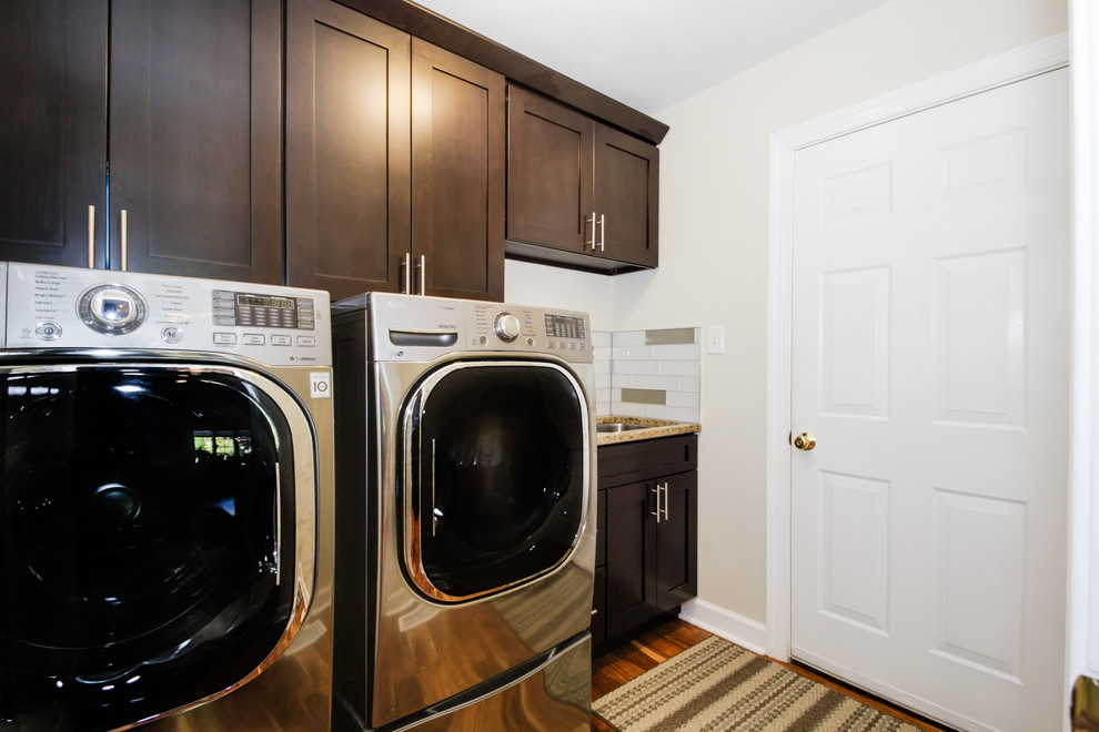 Inspiration for a mid-sized contemporary galley laundry cupboard in Other with an undermount sink, shaker cabinets, dark wood cabinets, quartz benchtops, white walls, dark hardwood floors and a side-by-side washer and dryer.