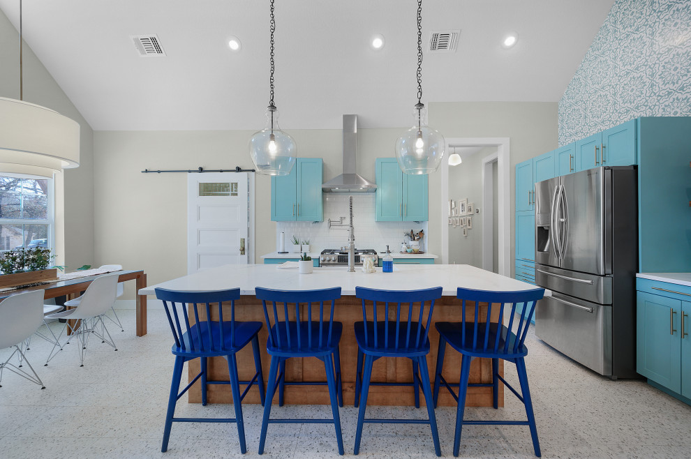 Large country l-shaped open plan kitchen in Dallas with vaulted, a drop-in sink, flat-panel cabinets, blue cabinets, quartz benchtops, white splashback, ceramic splashback, stainless steel appliances, terrazzo floors, with island, white floor and white benchtop.