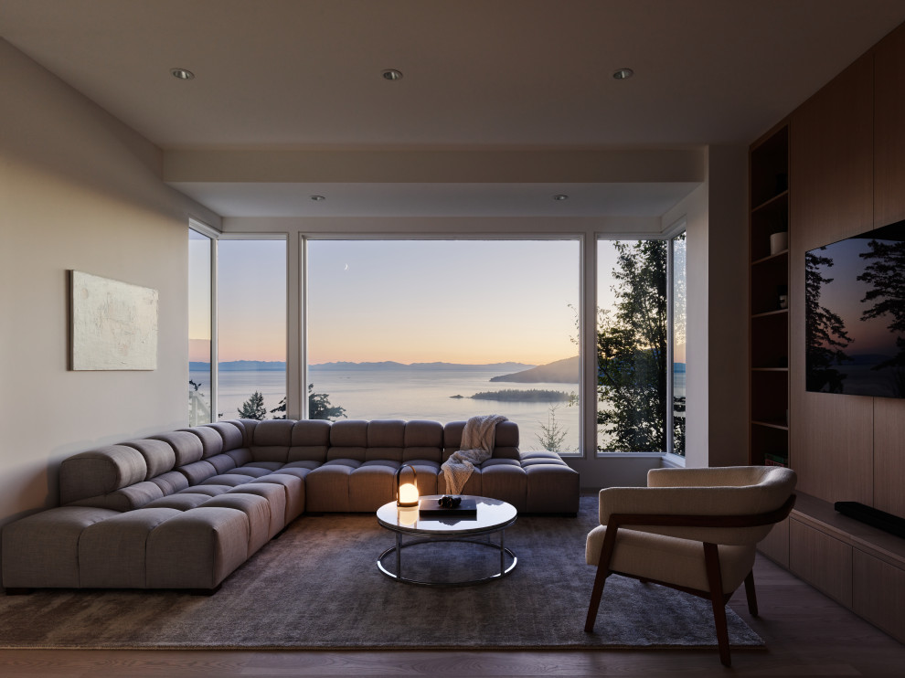 Пример оригинального дизайна: гостиная комната в стиле модернизм с телевизором на стене без камина