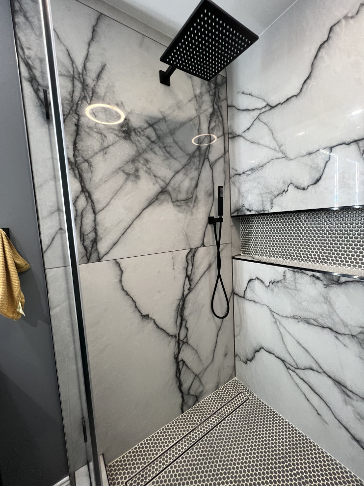 This is an example of a large contemporary master wet room bathroom in DC Metro with flat-panel cabinets, black cabinets, a one-piece toilet, black tile, porcelain tile, grey walls, vinyl floors, a vessel sink, engineered quartz benchtops, grey floor, a hinged shower door, black benchtops, a shower seat, a double vanity and a freestanding vanity.