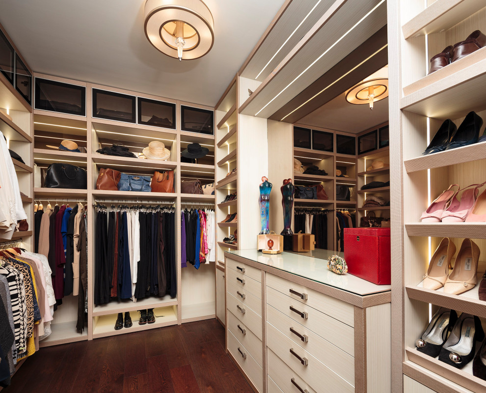 Inspiration pour un dressing room traditionnel pour une femme avec des portes de placard beiges et un sol en bois brun.