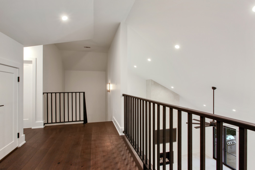 На фото: коридор среднего размера в стиле неоклассика (современная классика) с белыми стенами, темным паркетным полом, коричневым полом и сводчатым потолком с