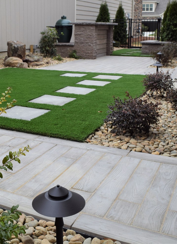 Photo of a mid-sized contemporary courtyard patio in Charlotte with a water feature, concrete pavers and no cover.