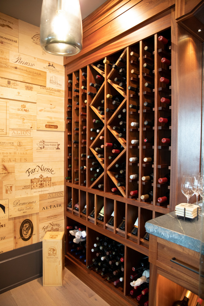 Photo of a small beach style wine cellar in Other with light hardwood floors, display racks and brown floor.