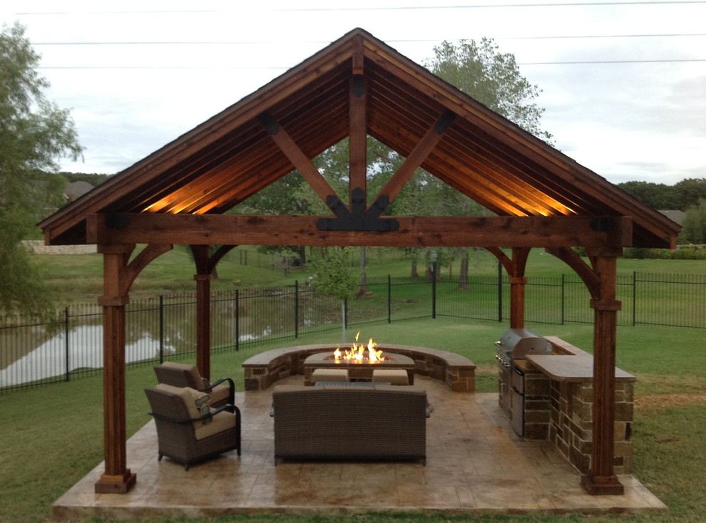 This is an example of a mid-sized arts and crafts backyard patio in Dallas with an outdoor kitchen, stamped concrete and a gazebo/cabana.