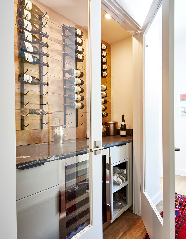 Inspiration for a small transitional wine cellar in Richmond with medium hardwood floors, display racks and brown floor.