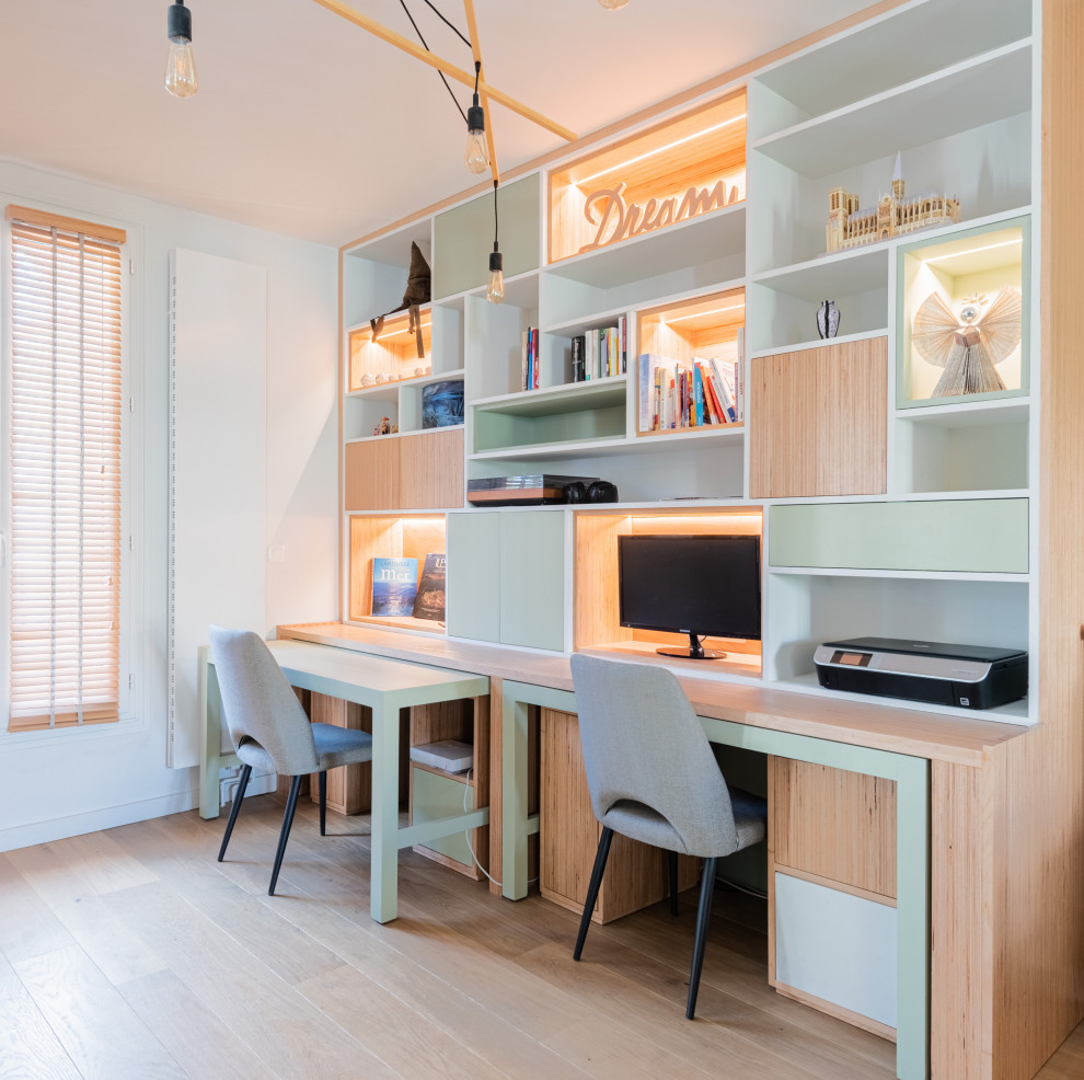 Großes Modernes Arbeitszimmer mit Arbeitsplatz, beiger Wandfarbe, hellem Holzboden, Kaminofen und Einbau-Schreibtisch in Paris