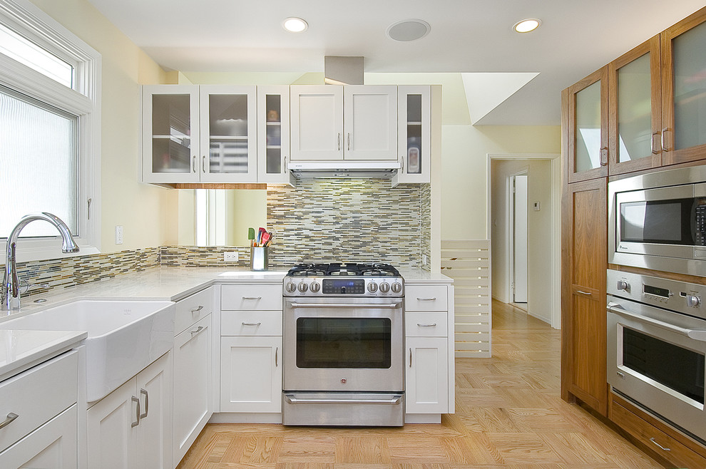 Photo of a contemporary kitchen in San Francisco with stainless steel appliances, a farmhouse sink, white cabinets, matchstick tile splashback and multi-coloured splashback.