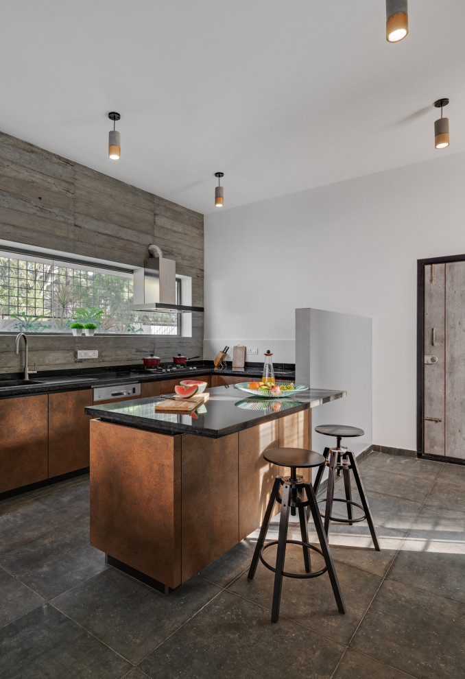 Photo of a mid-sized contemporary u-shaped kitchen in Bengaluru with a drop-in sink, flat-panel cabinets, orange cabinets, grey splashback, a peninsula, grey floor and black benchtop.
