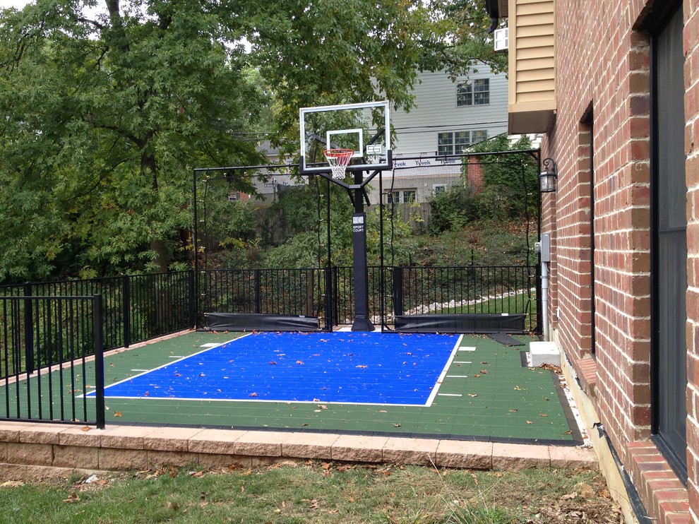 Small modern side yard partial sun outdoor sport court in St Louis with with outdoor playset.