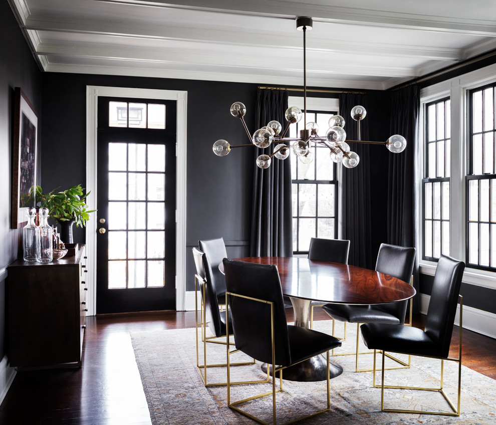 Photo of a transitional separate dining room in New York with black walls, dark hardwood floors and brown floor.