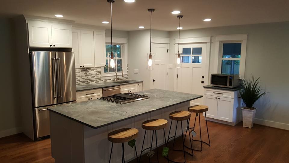 Open concept kitchen - large transitional l-shaped medium tone wood floor open concept kitchen idea in Baltimore with shaker cabinets, white cabinets, an island, soapstone countertops, multicolored backsplash, matchstick tile backsplash and stainless steel appliances