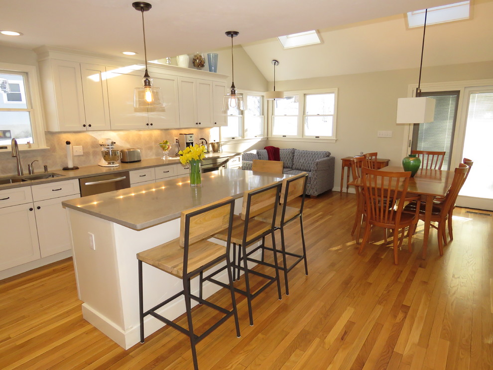Inspiration for a large transitional l-shaped medium tone wood floor kitchen remodel in Boston with an undermount sink, shaker cabinets, white cabinets, quartz countertops, gray backsplash, stainless steel appliances and an island