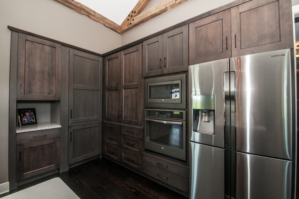 Inspiration for a large rustic dark wood floor and brown floor eat-in kitchen remodel with an undermount sink, flat-panel cabinets, medium tone wood cabinets, quartz countertops, green backsplash, glass sheet backsplash, stainless steel appliances and an island