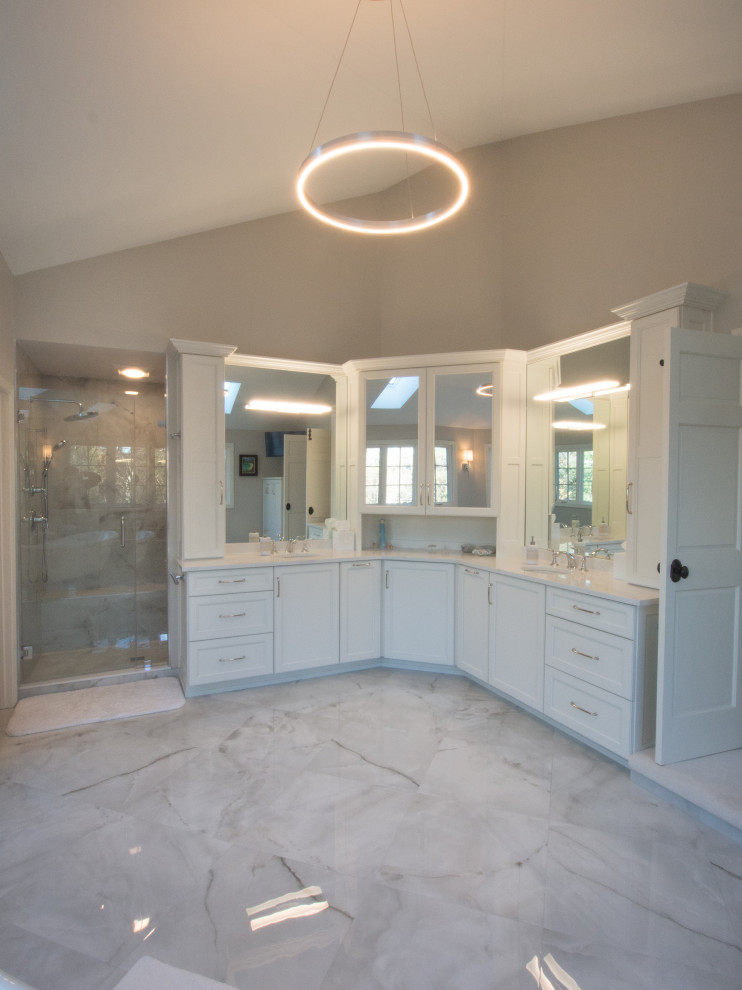 Immagine di una stanza da bagno con ante bianche, vasca con piedi a zampa di leone, pareti bianche, pavimento in marmo, top in marmo, top bianco e due lavabi