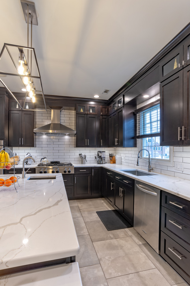 Design ideas for a mid-sized contemporary l-shaped eat-in kitchen in Philadelphia with an undermount sink, shaker cabinets, dark wood cabinets, quartz benchtops, white splashback, subway tile splashback, stainless steel appliances, porcelain floors, grey floor and white benchtop.