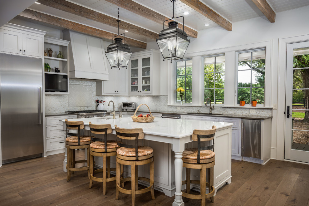Traditional kitchen in Charleston with an undermount sink, glass-front cabinets, stainless steel appliances, with island and dark hardwood floors.