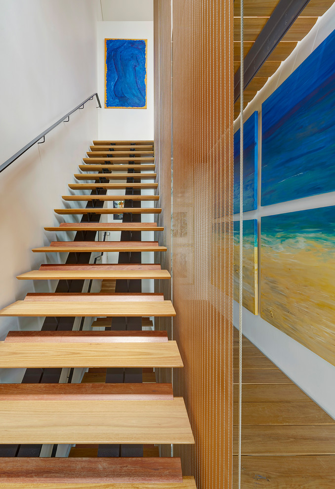 Large contemporary wood staircase in Sydney with wood risers and metal railing.