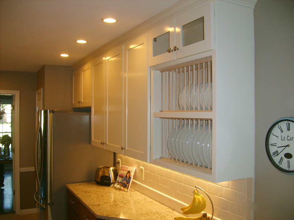 Example of a transitional galley eat-in kitchen design with an undermount sink, shaker cabinets, dark wood cabinets, quartz countertops, white backsplash, subway tile backsplash and stainless steel appliances