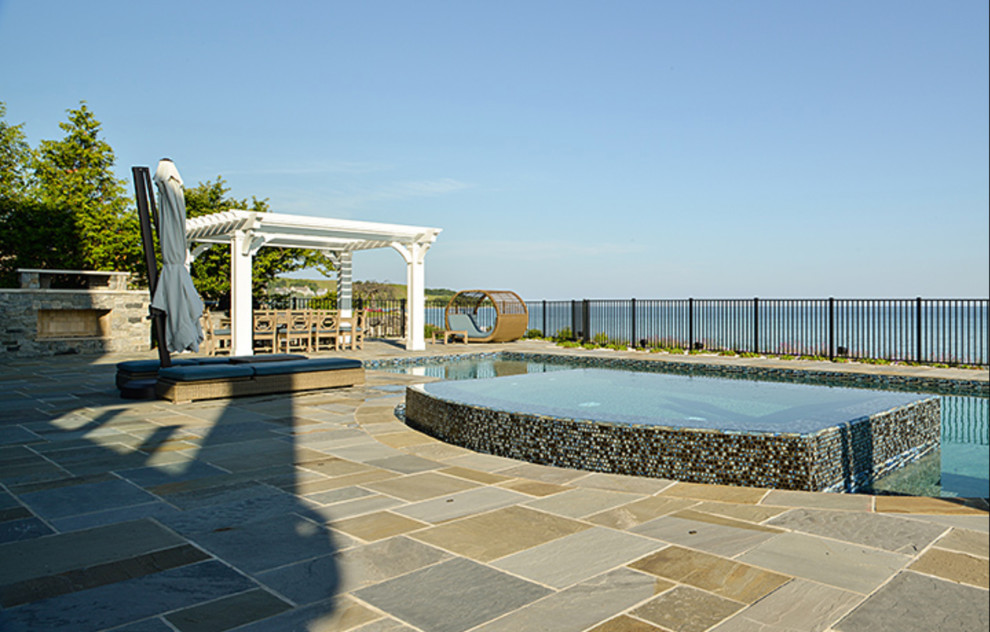 Inspiration for a large transitional backyard stone and custom-shaped natural hot tub remodel