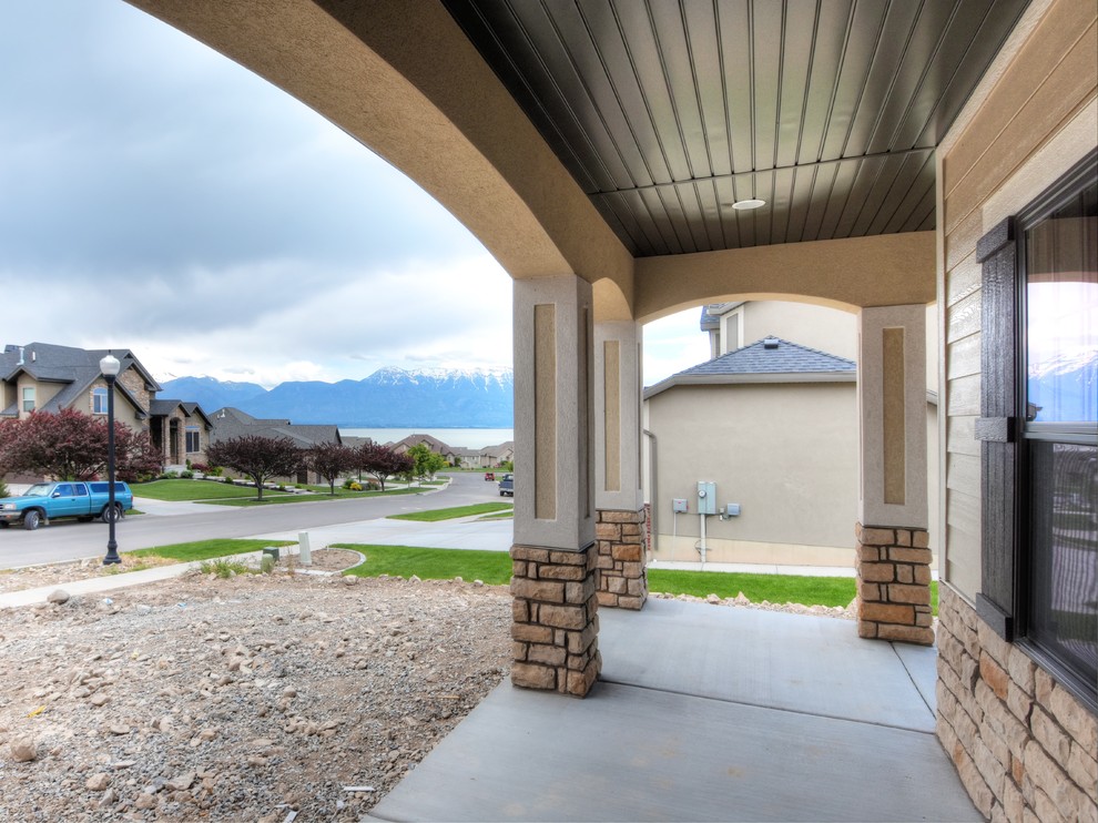 This is an example of a mid-sized arts and crafts front yard verandah in Salt Lake City with concrete slab and a roof extension.