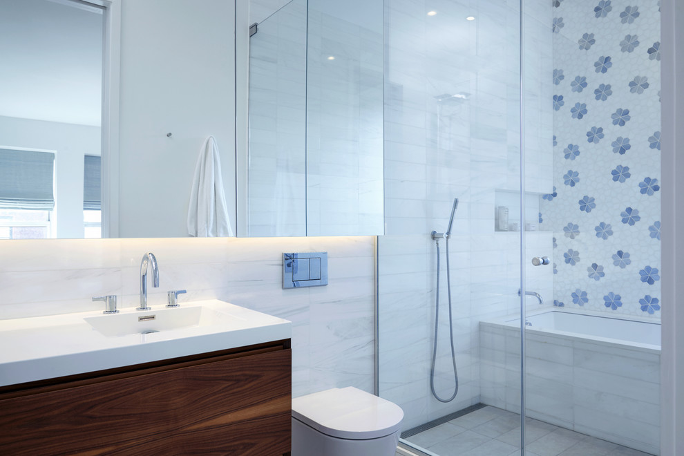 Design ideas for a contemporary wet room bathroom in New York with flat-panel cabinets, dark wood cabinets, an undermount tub, a wall-mount toilet, blue tile, white tile, white walls, an integrated sink, white floor and a hinged shower door.