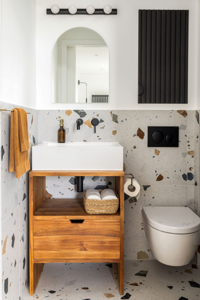 Inredning av ett modernt litet vit vitt en-suite badrum, med släta luckor, skåp i mellenmörkt trä, en dusch i en alkov, en vägghängd toalettstol, flerfärgad kakel, porslinskakel, flerfärgade väggar, klinkergolv i porslin, ett fristående handfat, bänkskiva i terrazo, flerfärgat golv och dusch med skjutdörr