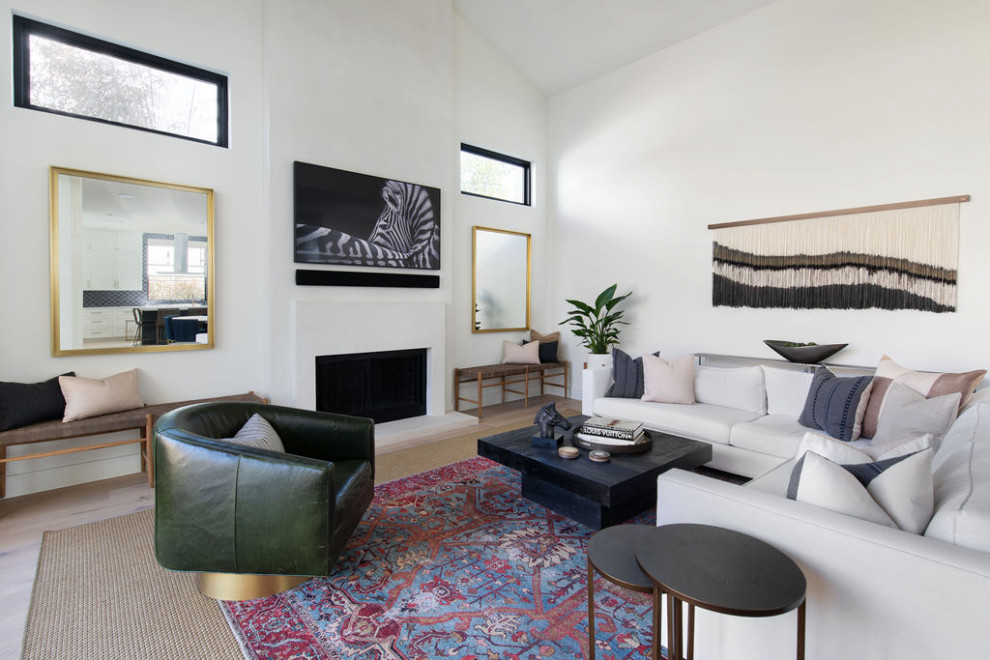 Aménagement d'un grand salon contemporain ouvert avec un mur blanc, parquet clair, un manteau de cheminée en plâtre, un téléviseur fixé au mur et un sol beige.