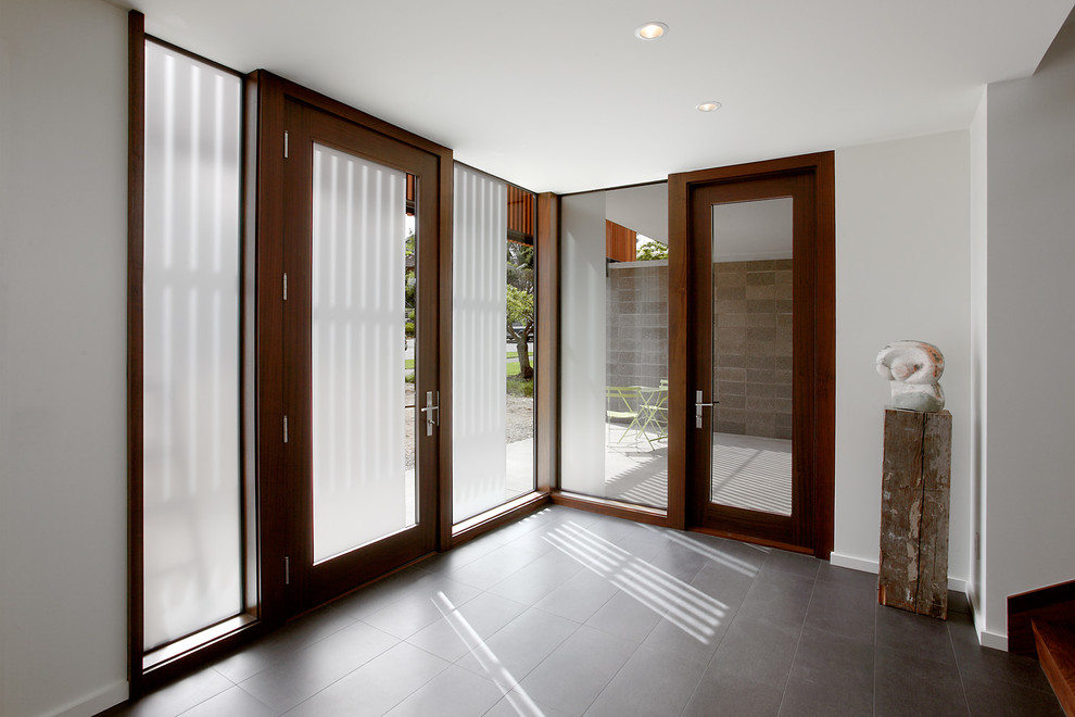 This is an example of a contemporary foyer in Seattle with white walls, ceramic floors, a double front door and a dark wood front door.