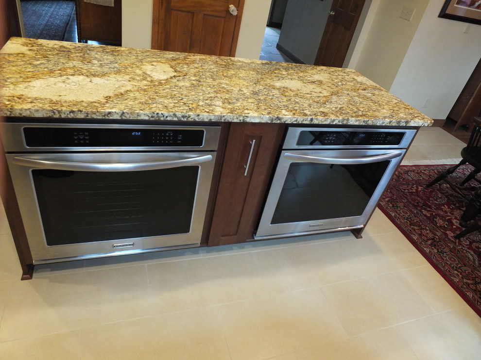 Inspiration for a mid-sized transitional l-shaped ceramic tile eat-in kitchen remodel in Columbus with an undermount sink, shaker cabinets, brown cabinets, granite countertops, beige backsplash, ceramic backsplash, stainless steel appliances and an island