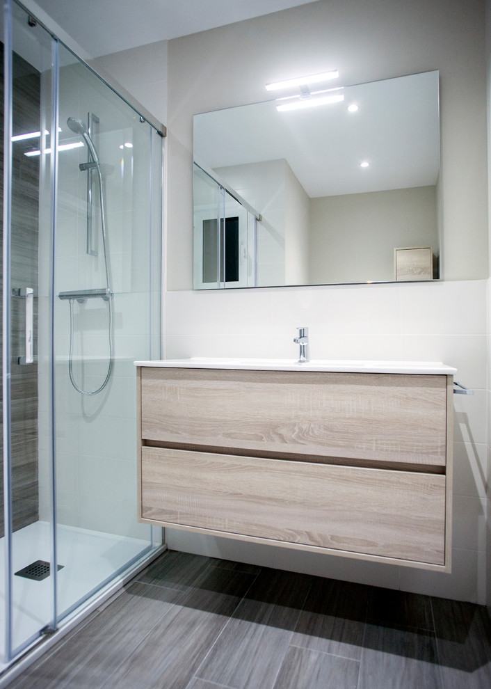 Inspiration for a mid-sized modern master bathroom in Barcelona with medium wood cabinets, a curbless shower, a one-piece toilet, white tile, beige walls, brown floor and a sliding shower screen.