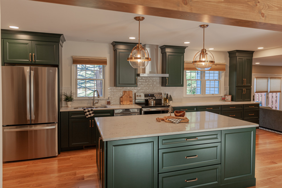 Mid-sized transitional single-wall medium tone wood floor, beige floor and exposed beam eat-in kitchen photo with a double-bowl sink, flat-panel cabinets, green cabinets, quartz countertops, white backsplash, ceramic backsplash, stainless steel appliances, an island and white countertops