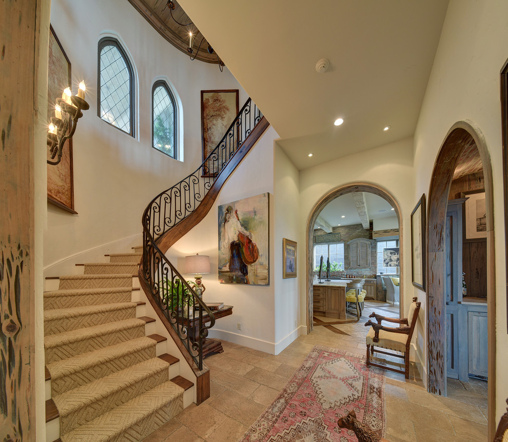 This is an example of a country wood curved staircase in Jacksonville with wood risers and metal railing.