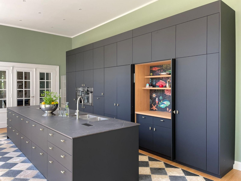 Modern inredning av ett mycket stort grå grått kök, med en dubbel diskho, släta luckor, grå skåp, marmorbänkskiva, grått stänkskydd, svarta vitvaror, klinkergolv i keramik, en köksö och vitt golv