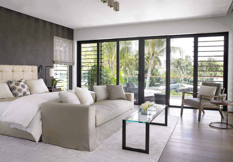 Photo of a contemporary master bedroom in Miami with grey walls, medium hardwood floors and brown floor.
