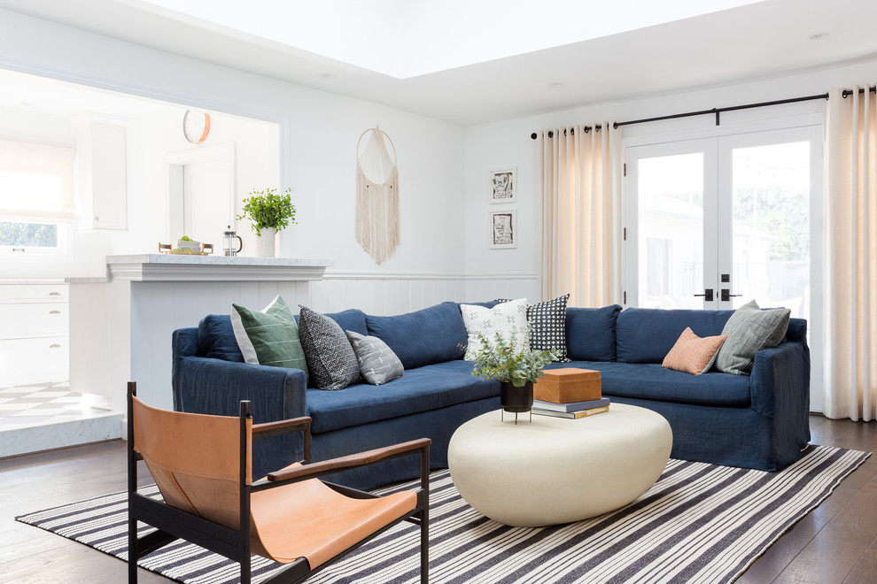 Example of a beach style open concept dark wood floor living room design in Los Angeles with white walls