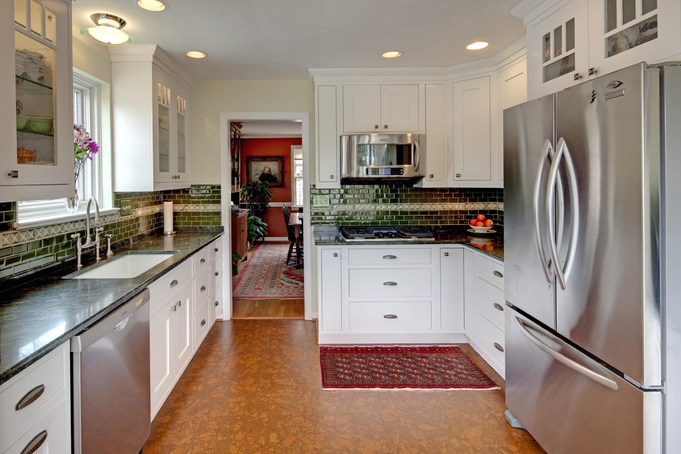 This is an example of a traditional u-shaped separate kitchen in DC Metro with glass-front cabinets, stainless steel appliances, an undermount sink, white cabinets, granite benchtops, green splashback and subway tile splashback.