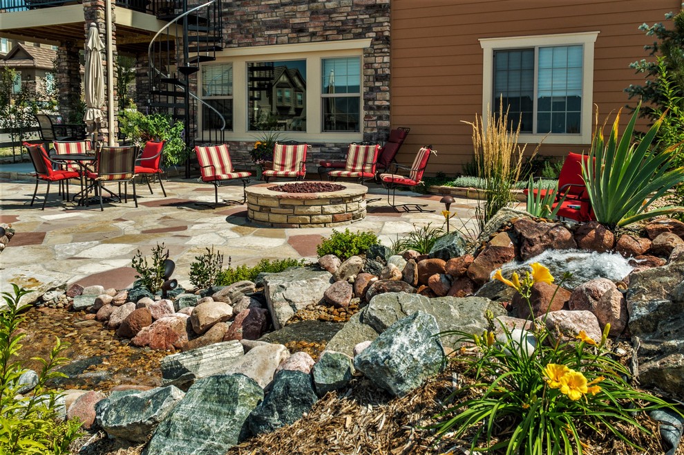 Design ideas for a large contemporary backyard patio in Denver with a fire feature and natural stone pavers.