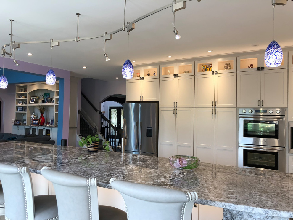 Inspiration for an expansive arts and crafts l-shaped eat-in kitchen in Atlanta with a double-bowl sink, flat-panel cabinets, grey cabinets, granite benchtops, grey splashback, mosaic tile splashback, stainless steel appliances, cement tiles, with island, grey floor and grey benchtop.