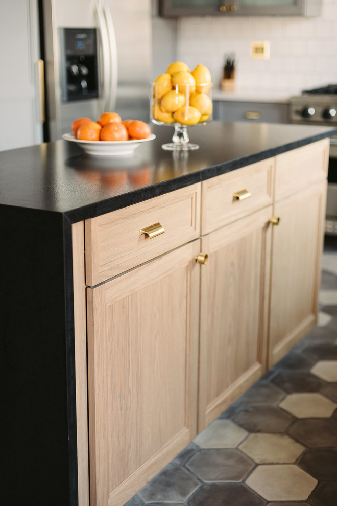 Inspiration for a large contemporary l-shaped cement tile floor and gray floor open concept kitchen remodel in Los Angeles with a double-bowl sink, raised-panel cabinets, brown cabinets, marble countertops, white backsplash, ceramic backsplash, stainless steel appliances and an island