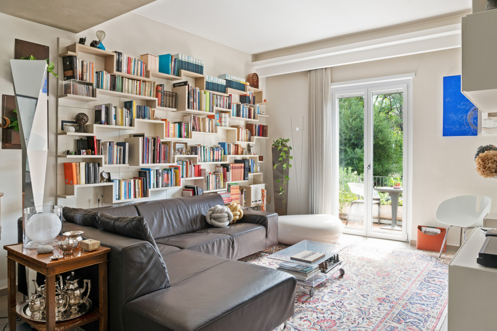 This is an example of a contemporary open concept living room in Rome with a library and beige walls.