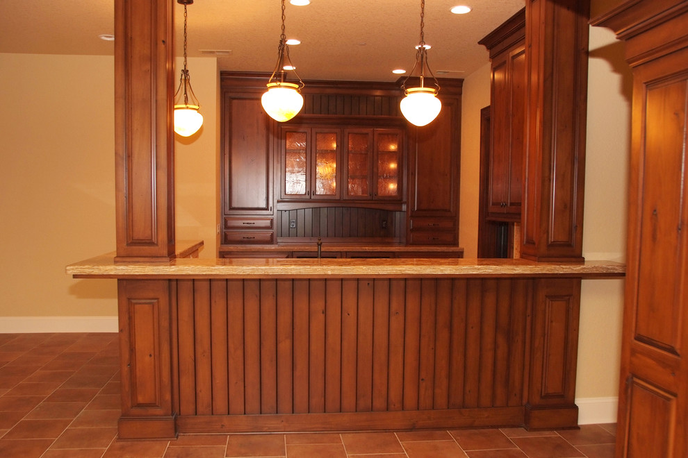Photo of a large traditional u-shaped wet bar in Portland with no sink, shaker cabinets, medium wood cabinets, ceramic floors and red floor.