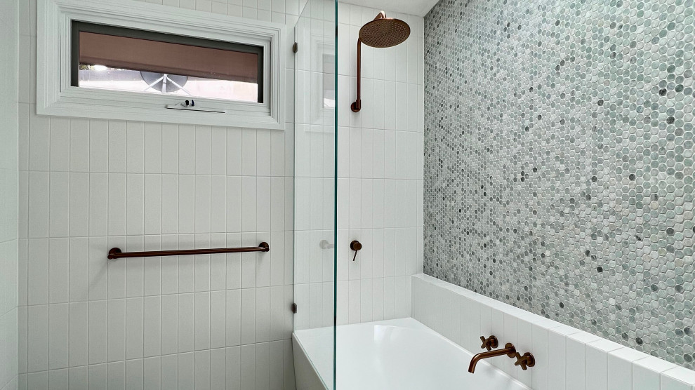 Bild på ett litet funkis vit vitt en-suite badrum, med möbel-liknande, bruna skåp, ett hörnbadkar, en dusch/badkar-kombination, en vägghängd toalettstol, vit kakel, keramikplattor, vita väggar, klinkergolv i keramik, ett konsol handfat, bänkskiva i kvarts, grönt golv och med dusch som är öppen