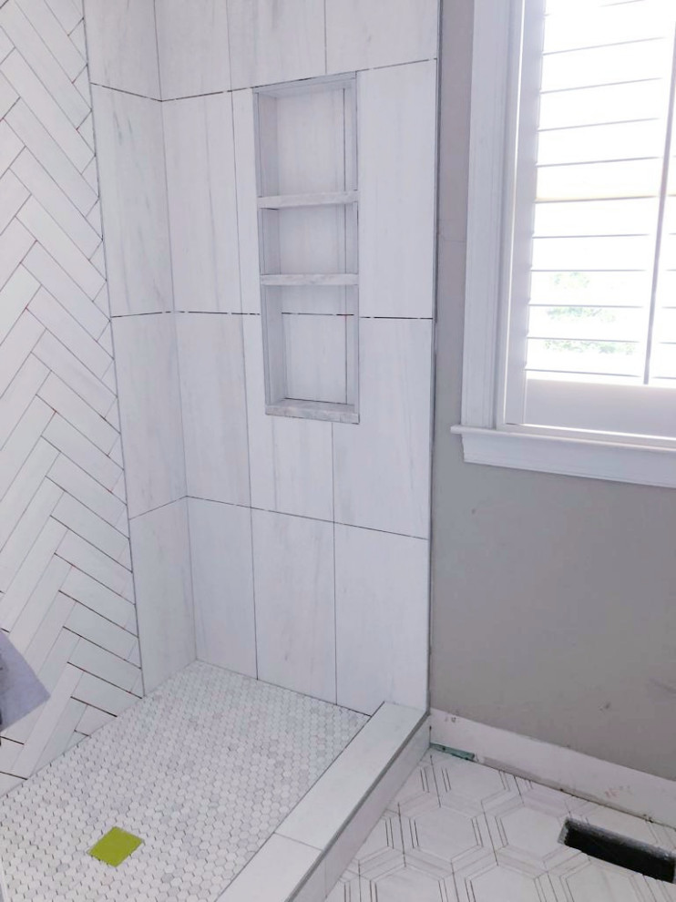 Photo of a medium sized classic grey and white ensuite bathroom in Atlanta with shaker cabinets, white cabinets, an alcove shower, a one-piece toilet, white tiles, marble tiles, white walls, marble flooring, a submerged sink, marble worktops, white floors, a hinged door, white worktops, feature lighting, a single sink, a freestanding vanity unit and a wallpapered ceiling.