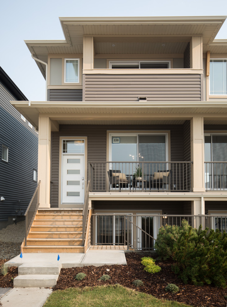 Inspiration for a mid-sized scandinavian beige two-story townhouse exterior remodel in Calgary
