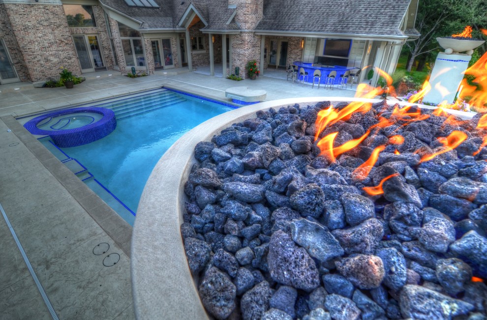 Example of a large transitional backyard concrete paver and rectangular natural hot tub design in Cedar Rapids