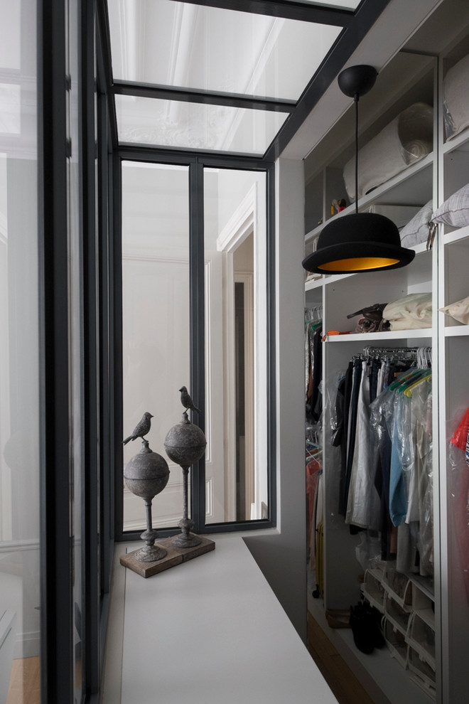 Mid-sized contemporary gender-neutral storage and wardrobe in Paris with open cabinets and white cabinets.
