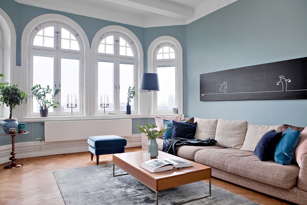 Inspiration for a mid-sized traditional enclosed living room in Malmo with blue walls, medium hardwood floors and orange floor.