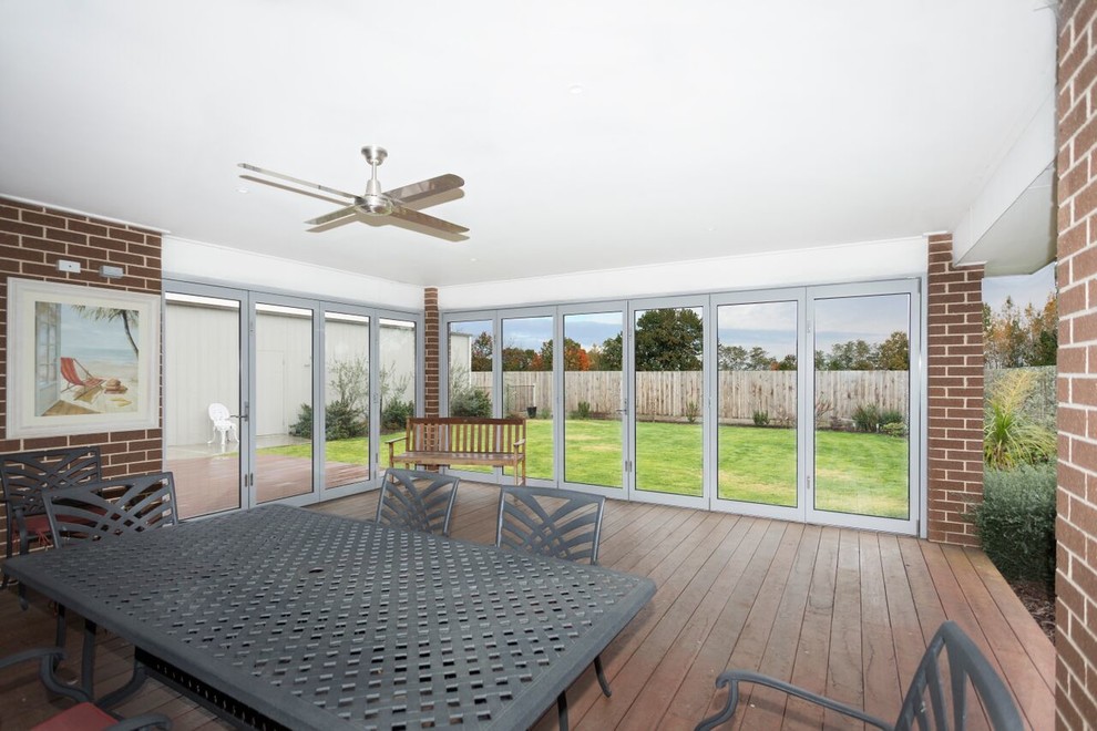 Design ideas for a mid-sized contemporary sunroom in Melbourne with a standard ceiling and brown floor.
