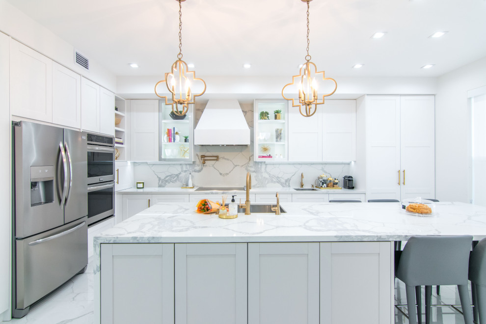 Open concept kitchen - large transitional l-shaped porcelain tile and white floor open concept kitchen idea in Miami with shaker cabinets, white cabinets, quartz countertops, an island, white countertops, an undermount sink, white backsplash, porcelain backsplash and stainless steel appliances